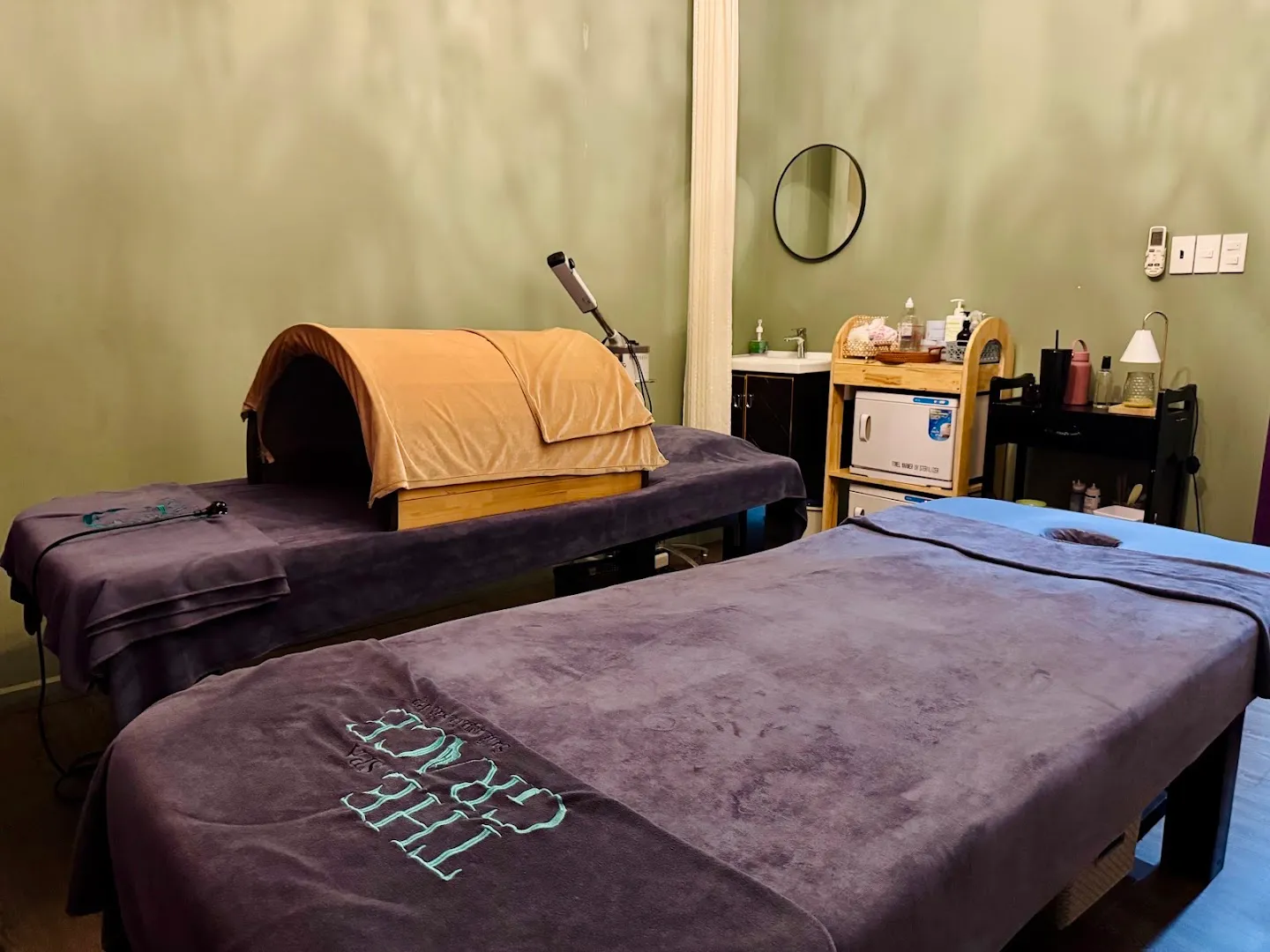 Phòng trị liệu với hai giường spa và thiết bị chăm sóc thư giãn.