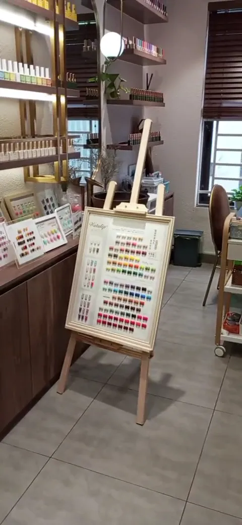Bảng mẫu màu sơn móng và kệ trưng bày sản phẩm trong không gian làm đẹp.
