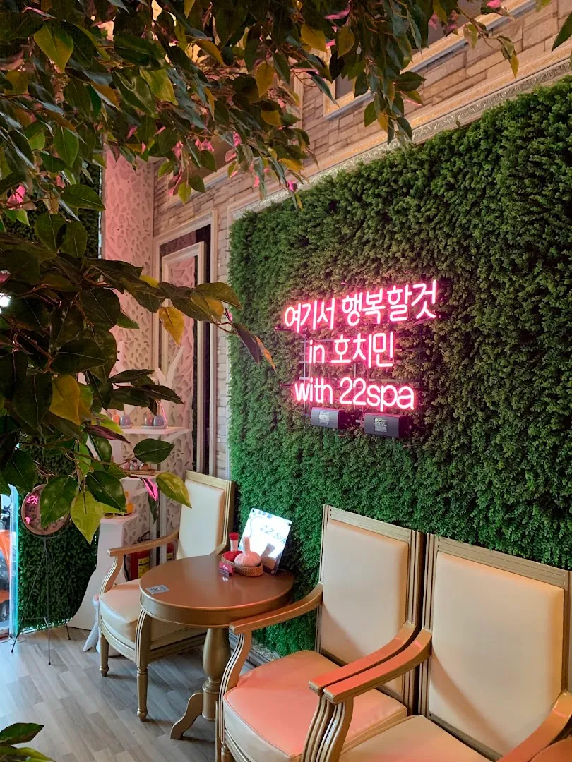 Không gian ghế ngồi trang trí cây xanh và bảng đèn neon của 22Spa.
