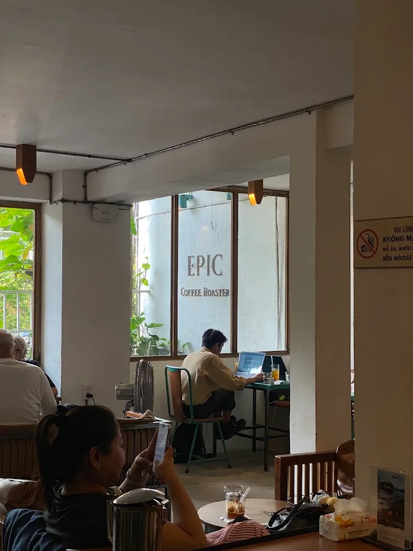 Không gian bên trong Epic Coffee Roaster với bàn ghế, cửa sổ thoáng và khách đang sử dụng quán.