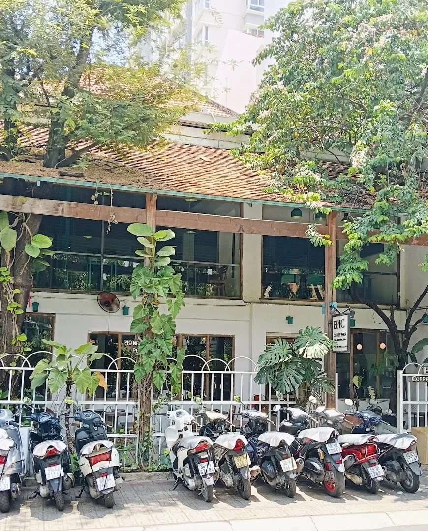 Mặt tiền Epic Coffee Roaster với biển hiệu, không gian cây xanh và khu vực để xe phía trước.