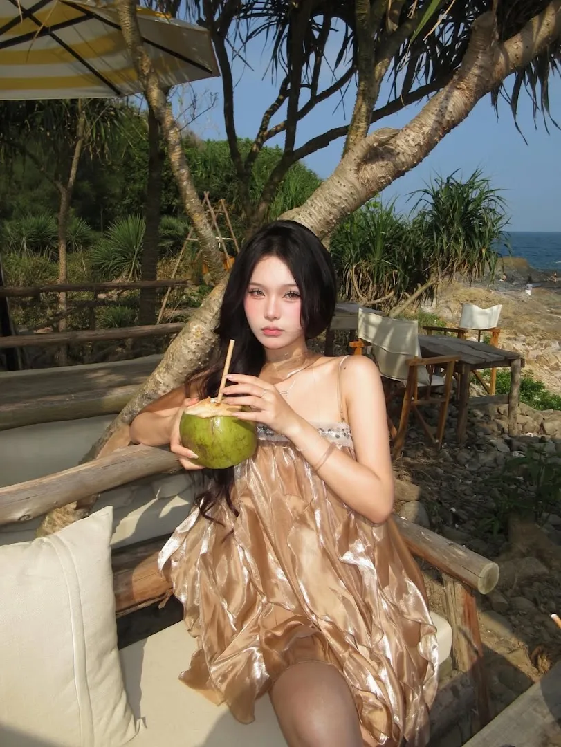 Không gian quán ngoài trời với bàn ghế gỗ hướng ra biển.