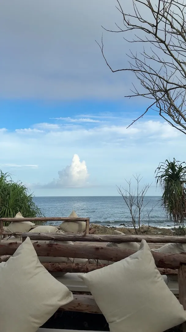Không gian ghế đệm hướng ra biển và bãi đá ven bờ.