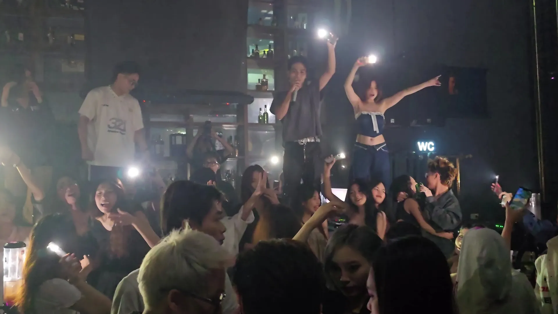 Không khí sôi động với màn biểu diễn và đám đông khán giả trong quán bar.