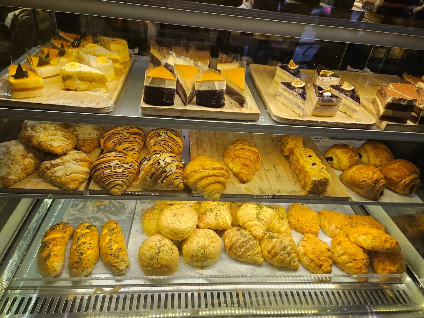Tủ bánh trưng bày nhiều loại bánh ngọt, bánh mì và bánh nướng.