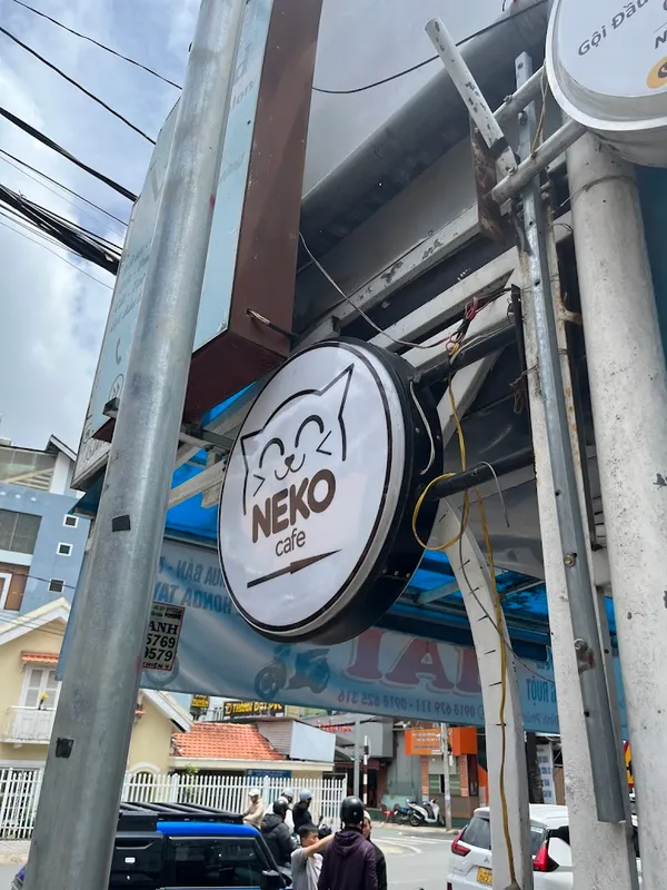 Biển hiệu tròn Neko Cafe tại mặt tiền quán.