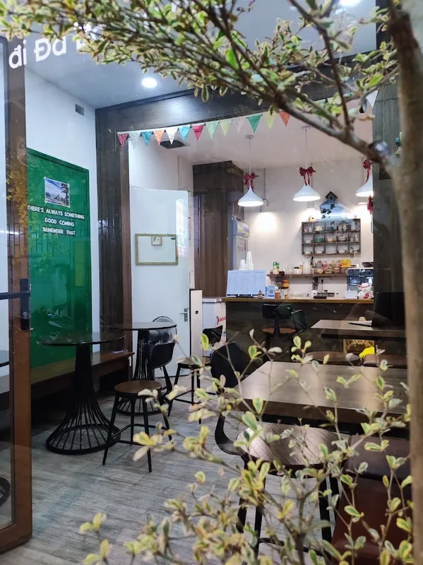 Không gian bên trong quán với bàn ghế, quầy pha chế và ánh đèn ấm cúng.