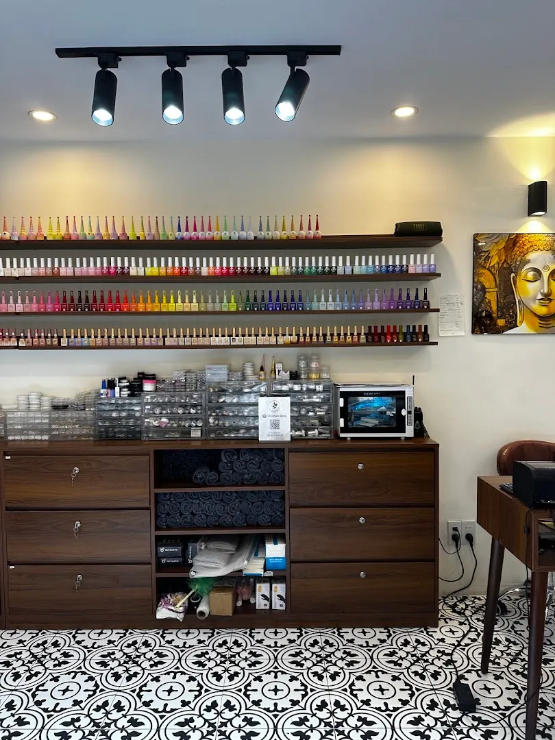 Kệ trưng bày nhiều màu sơn móng và dụng cụ làm nail trong không gian spa.