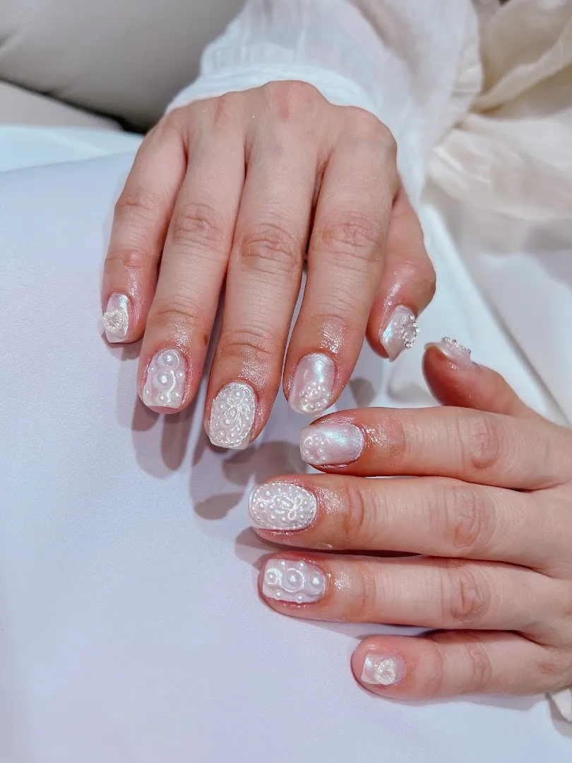 Mẫu móng tay đính đá và họa tiết nổi màu trắng ánh ngọc trai