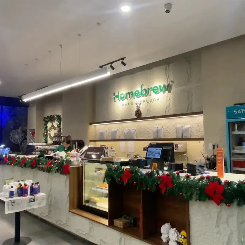 Quầy phục vụ và không gian bên trong Homebrew Café, với khu vực thanh toán và tủ bánh.