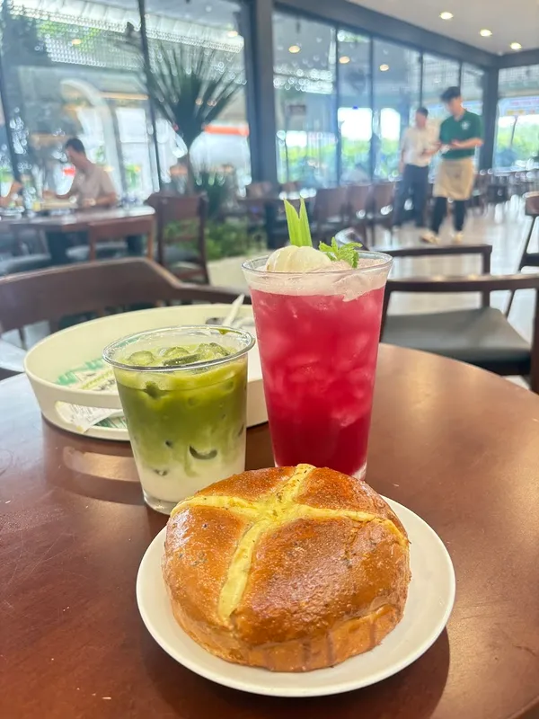 Đồ uống mát lạnh và bánh nướng được phục vụ trên bàn trong không gian quán cà phê.