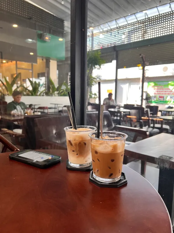 Hai ly cà phê đá trên bàn trong không gian quán.