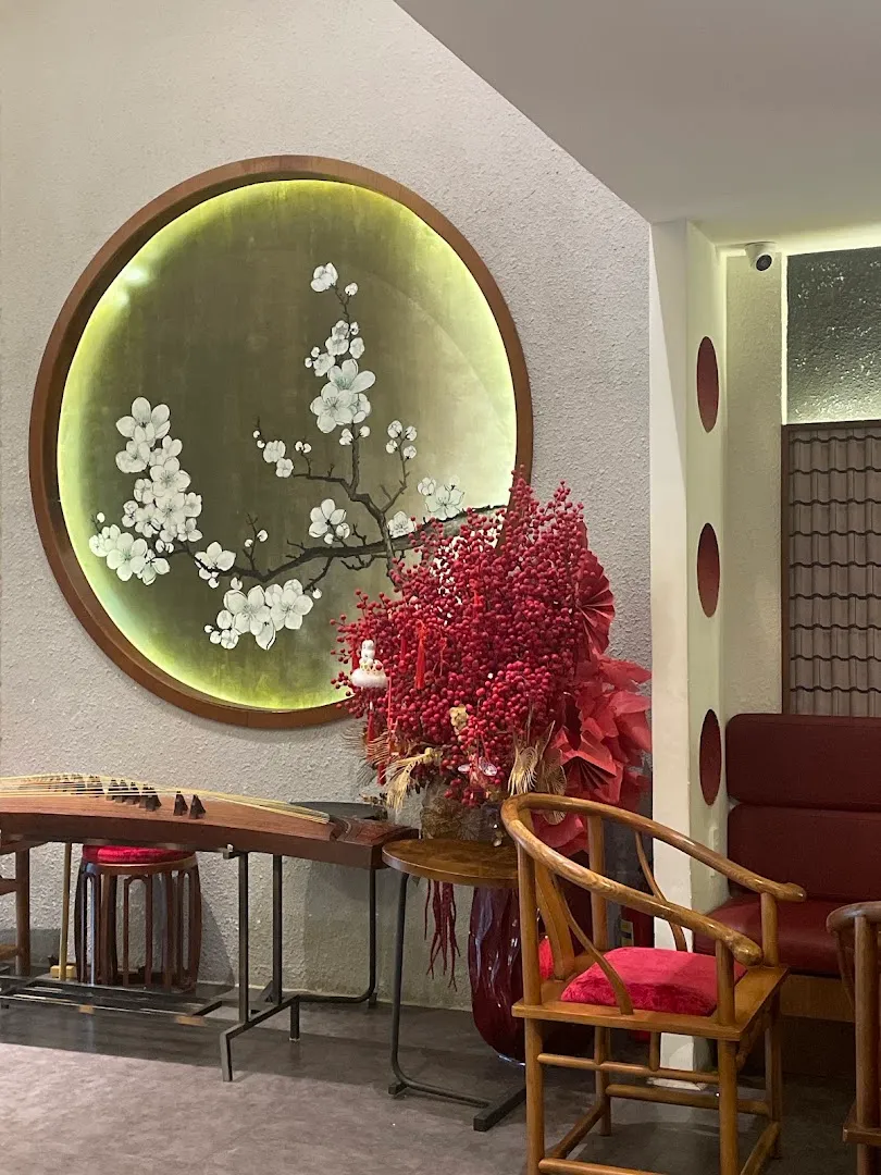 Không gian sảnh thư giãn với tranh hoa, bàn gỗ và ghế ngồi.