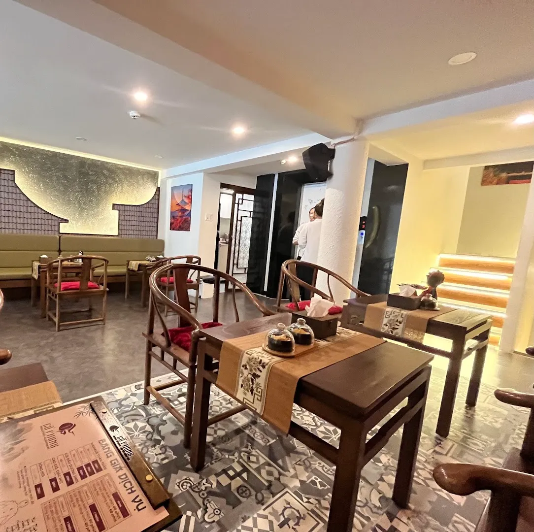 Không gian thư giãn với bàn ghế gỗ, khu vực tiếp khách và ánh sáng ấm áp.