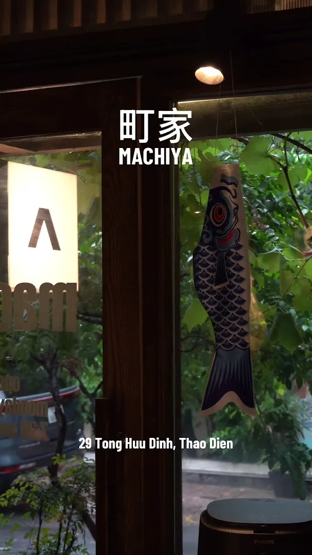 Mặt tiền cửa kính của Machiya Coffee với biển hiệu Machiya và trang trí cá koi.