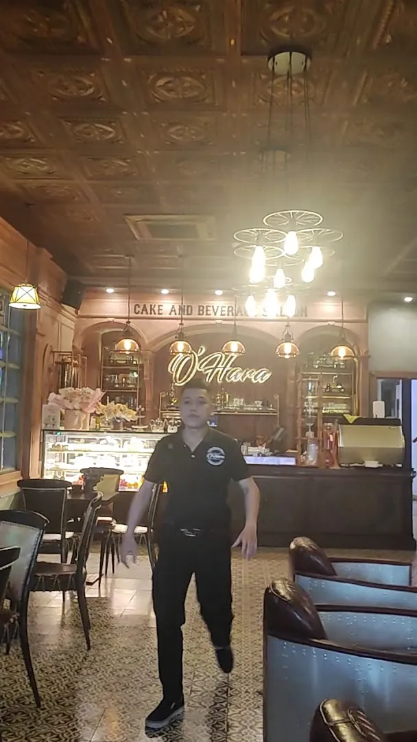 Không gian quán với quầy pha chế, khu trưng bày bánh và bàn ghế ngồi.