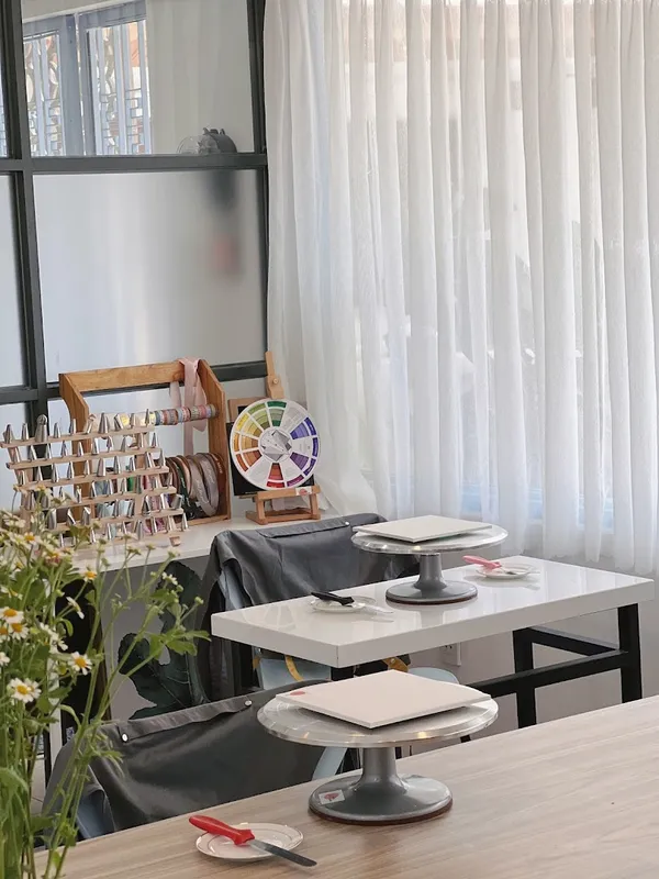 Không gian bàn học làm bánh với bàn xoay, dụng cụ trang trí và kệ ruy-băng.