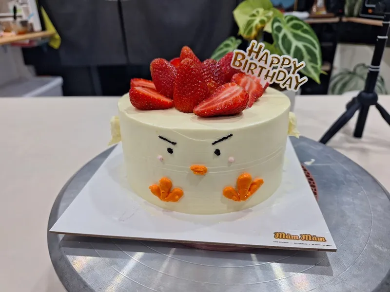 Bánh kem tạo hình chú vịt, trang trí dâu tây và dòng chữ “Happy Birthday”.